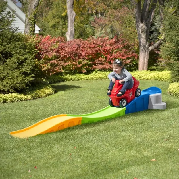 toddler riding red ride-on car on rainbow roller coaster track