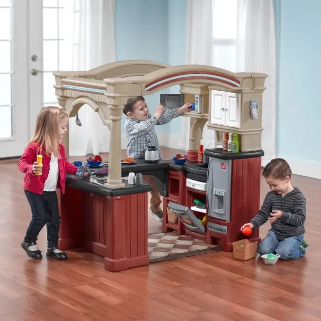 children playing with Step2 gourmet kitchen playset