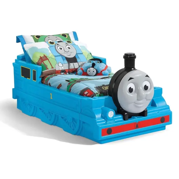Toddler boy reading in a blue Thomas the Tank Engine-themed bed with smiling front design at Butterflies Toys, HSR Layout, Bengaluru.